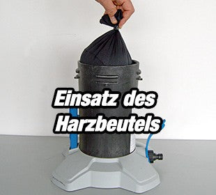 Person demonstriert den Einsatz eines Harzbeutels in einem zylindrischen Gerät.